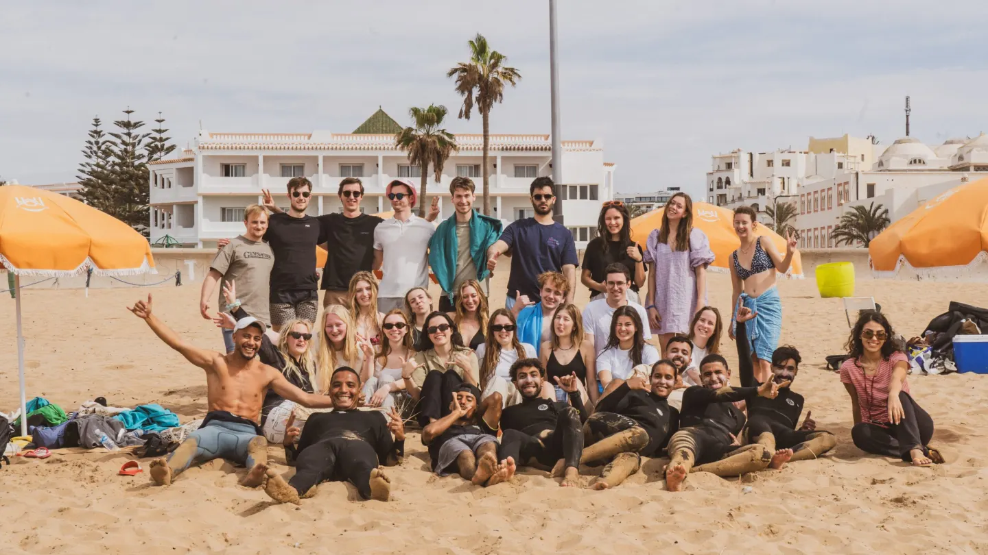 Duża grupa surferów i instruktorów Wave Rise na plaży w Agadirze