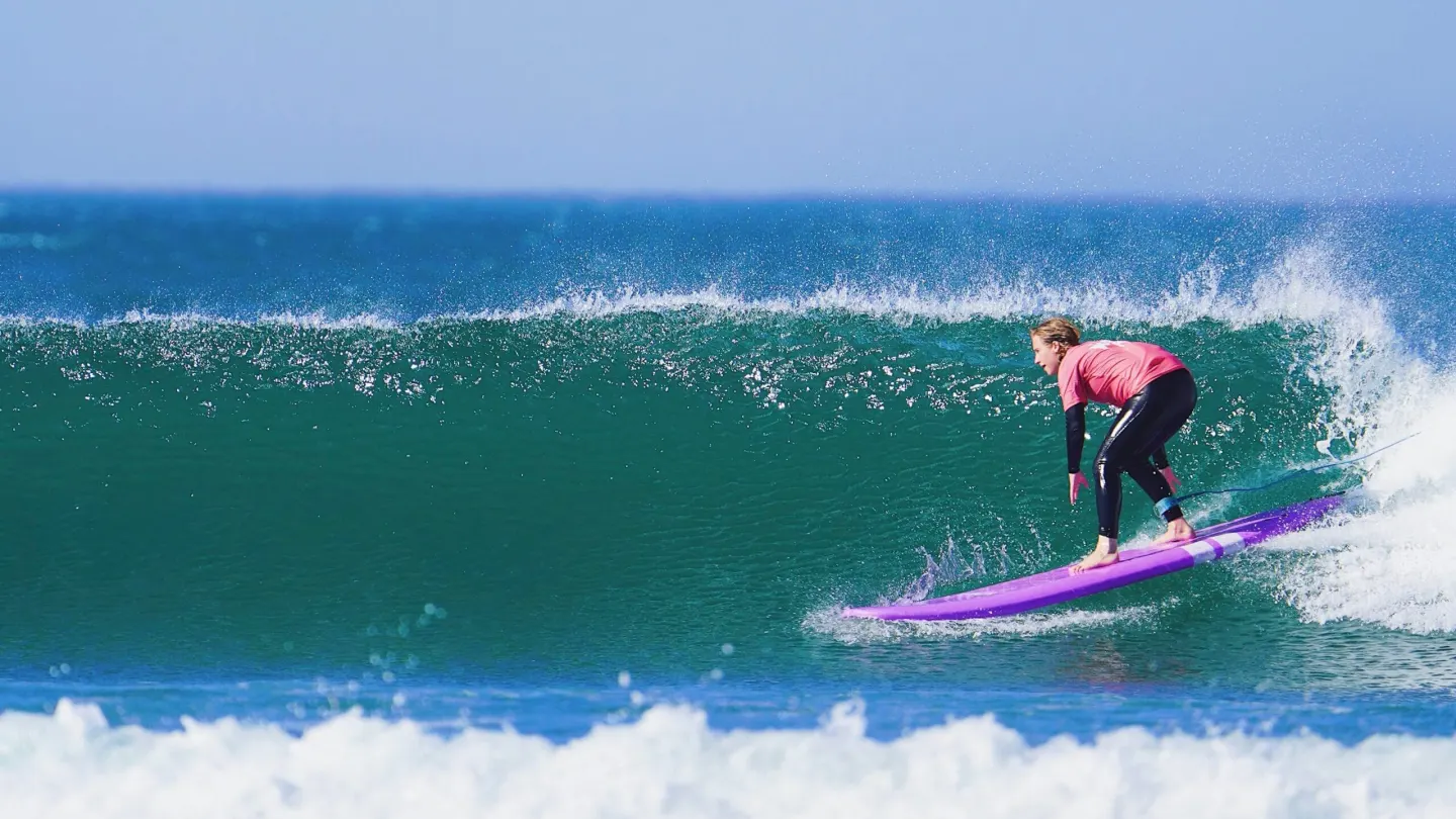 Un surfista che percorre un'onda turchese pulita
